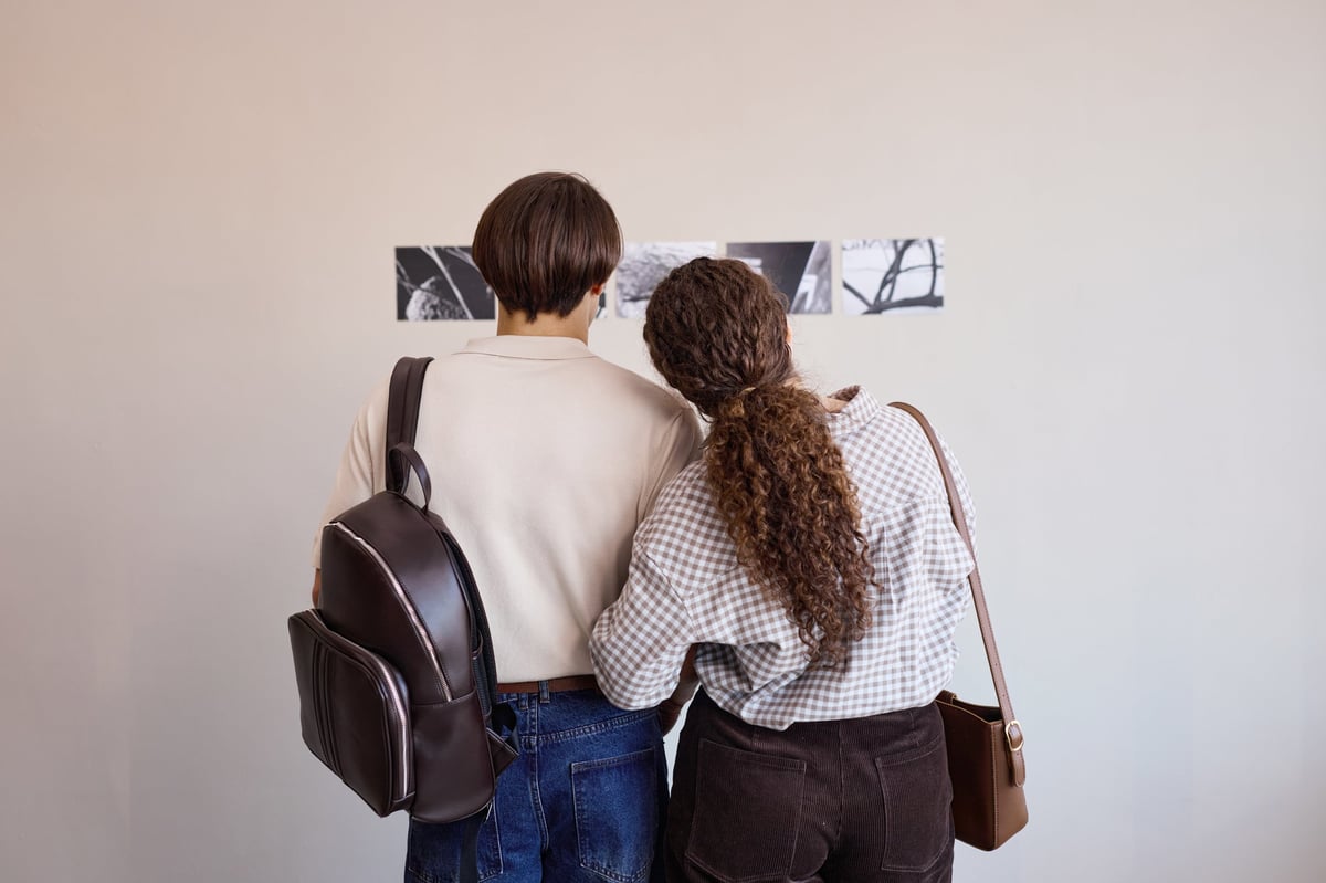 Two visitors viewing black and white photographs in a gallery