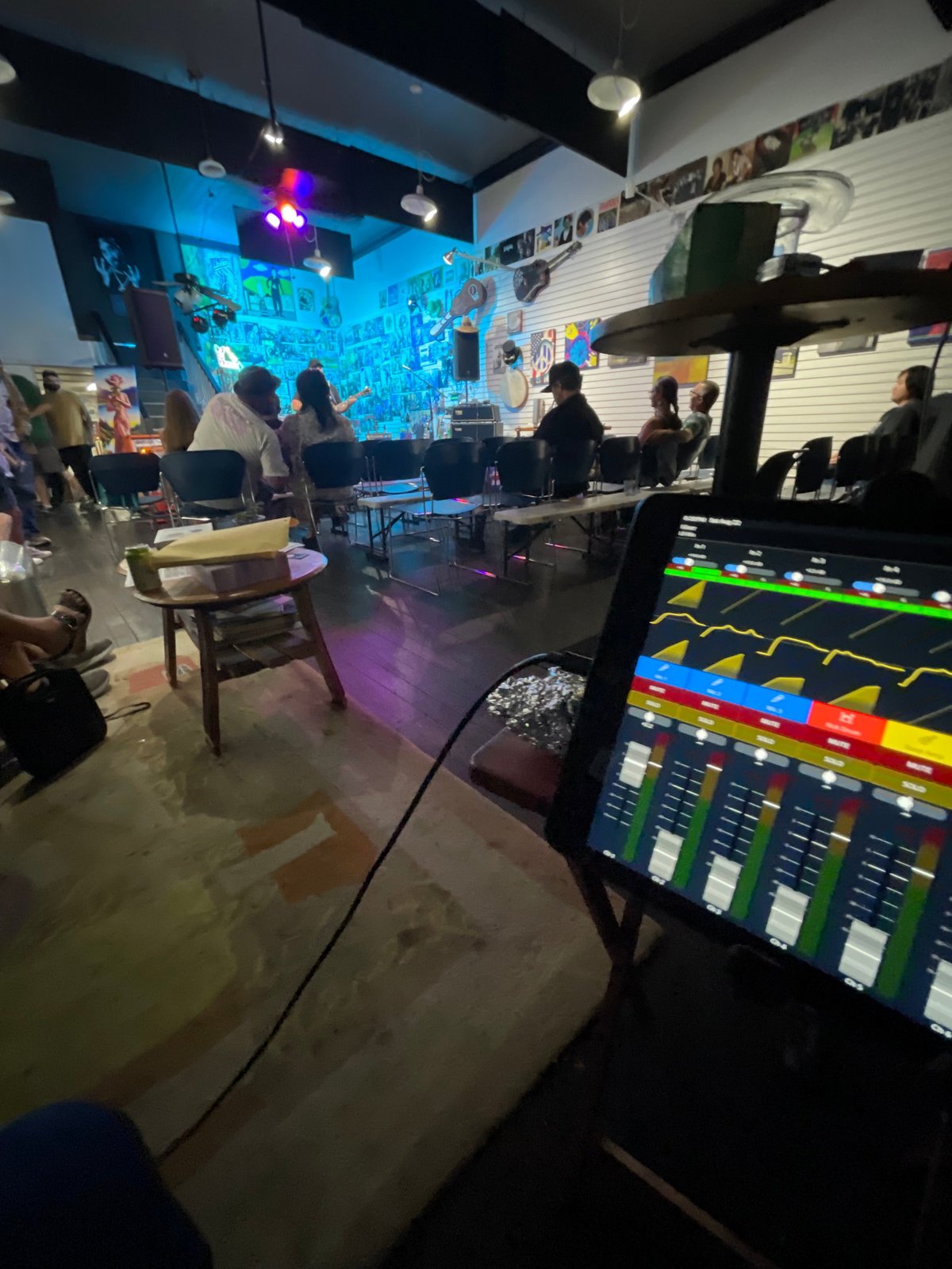 Intimate live music showcase inside the studio with seated audience, stage lighting, and sound mixing at the front of house